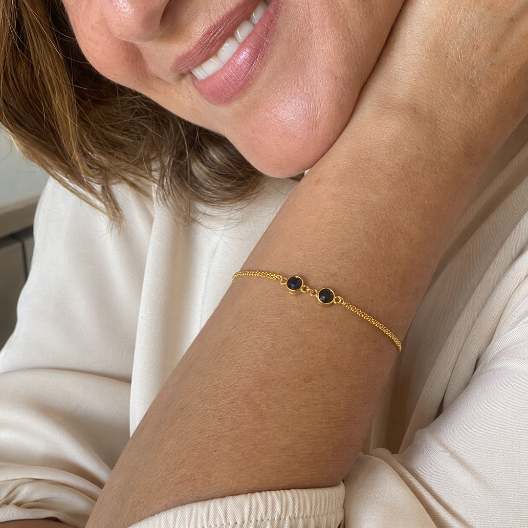 Mulher loira usando a Pulseira Duo dourada no pulso