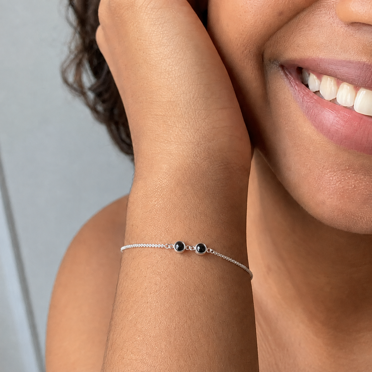 Mulher negra usando a Pulseira Duo prateada no pulso