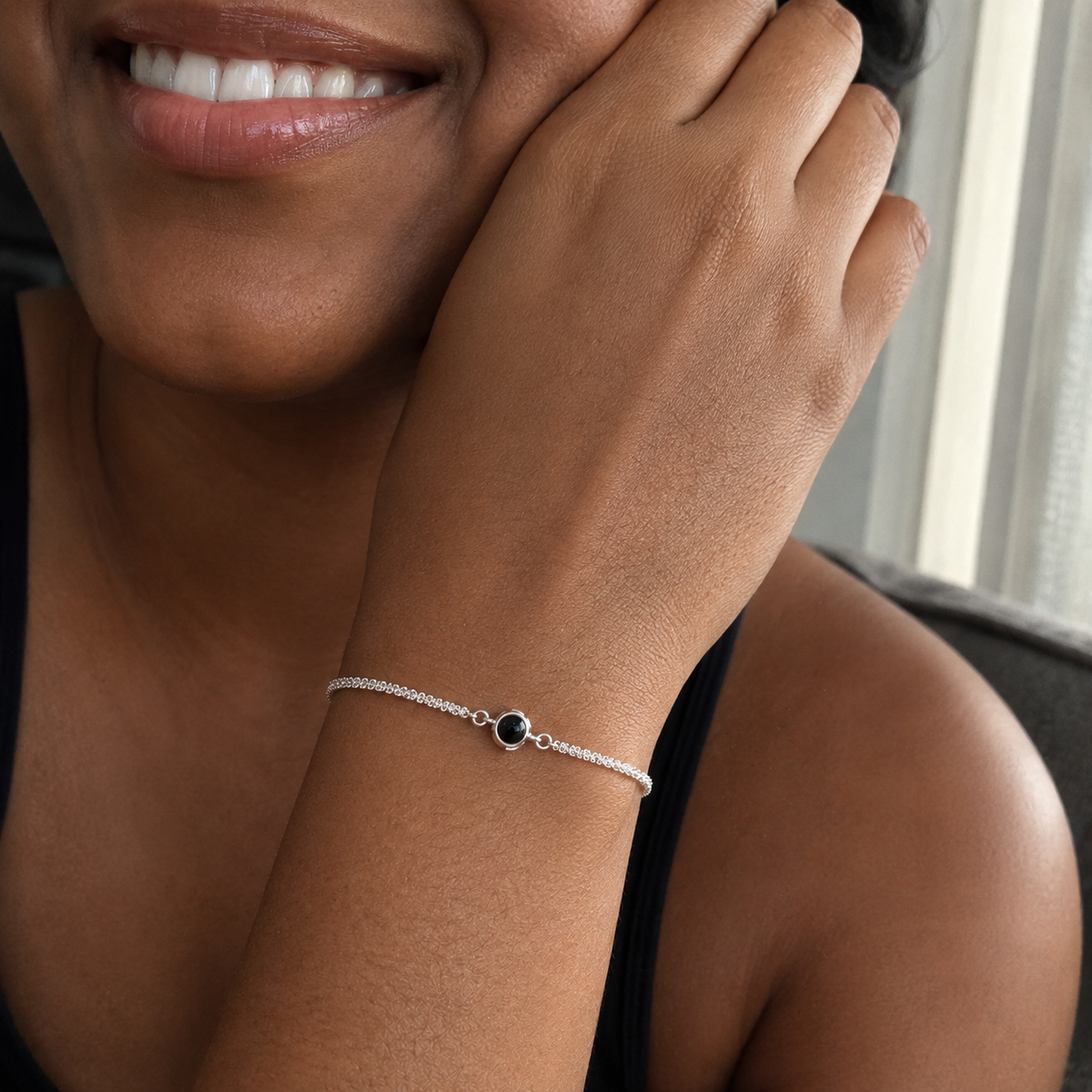 Mulher negra usando a Pulseira Uni prateada no pulso